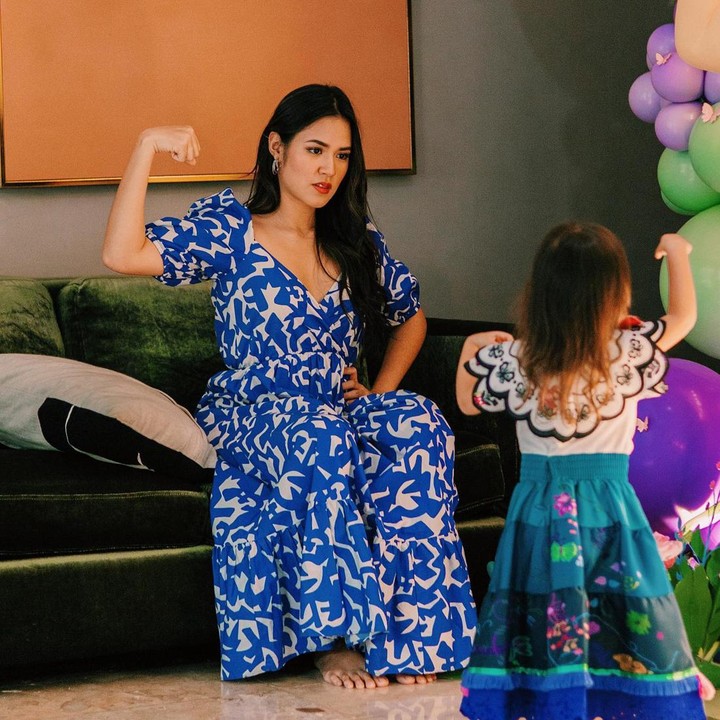 <p>Tak cuma dekorasi yang bertema Encanto lho. Kostum yang dikenakan Zalina juga mirip tokoh di film ini. Zalina tampil cantik dengan baju putih dan rok berwarna biru dengan motif bunga. (Foto: Instagram @raisa6690)</p>