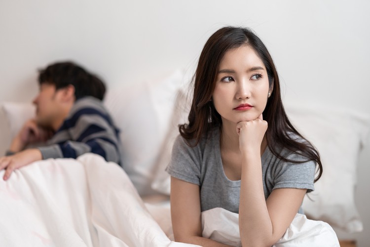 Asian Couple relationship difficulties, conflict and people concept - unhappy Asian couple having an argument at bedroom