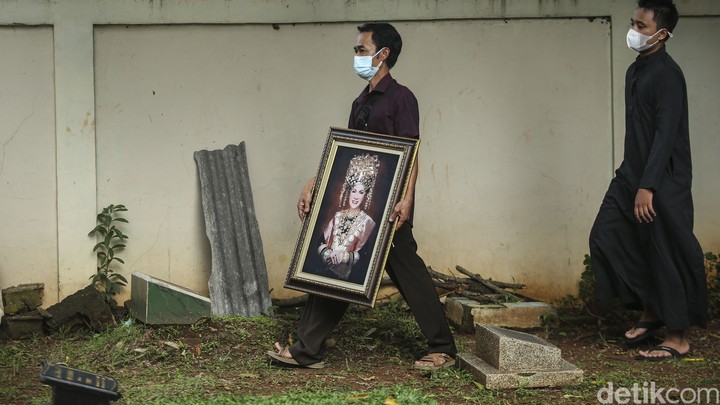 Sejumlah petugas memakamkan jenazah Dorce Gamalama di TPU Bantar Jati, Jakarta Timur, Rabu (16/2/2022). Pemakaman tersebut menggunakan prokes COVID-19.