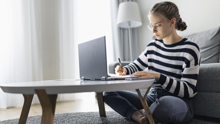 Teenage girl during COVID-19 lockdown attending to online class from home. The school has been closed during coronavirus outbreak and the classes have moved to e-learning platform.

Shot with Canon R5