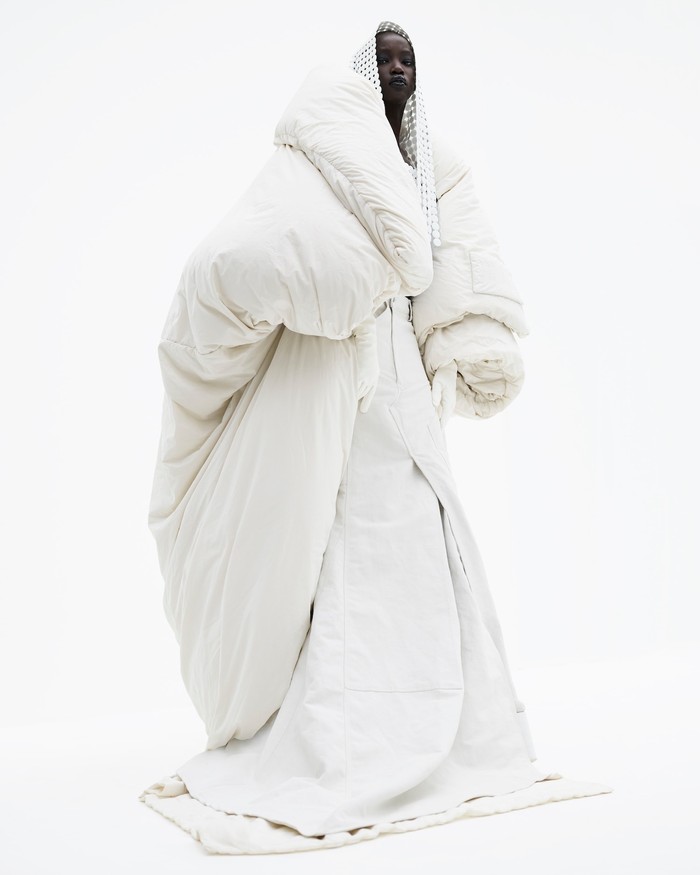 Puffer coat panjang yang dramatis berpadu dengan gaun putih. Terlihat sulit dikenakan sehari-hari, tak menutup kemungkinan bila Marc Jacobs akan menerjemahkannya ke dalam desain yang lebih wearable. Foto: courtesy of Marc Jacobs
