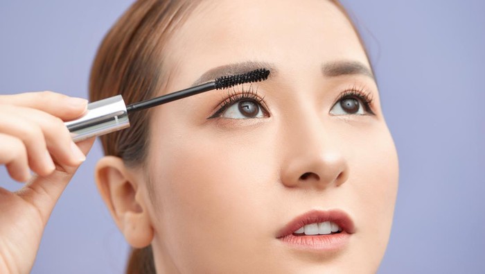 beautiful young woman applied mascara, studio beauty portrait