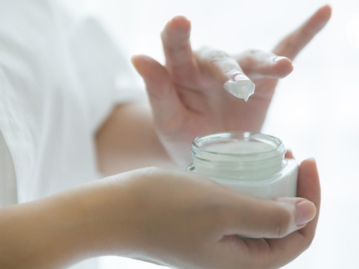 Memakai pelembap untuk skincare routine perempuan usia 40-an.