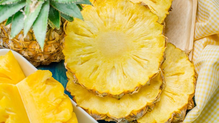 nanas Fresh pineapple with slices on the wood texture background