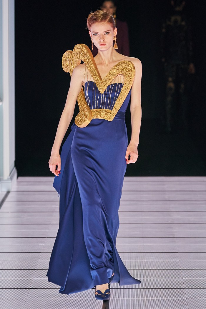 Jeremy Scott selaku direktur kreatif juga mengkreasikan inspirasi alat musik dalam koleksi Moschino di Milan Fashion Week Fall 2022 kemarin. Ornamen harpa emas terpadu apik menjadi one-shoulder dress yang mewah. Foto: vogue.com