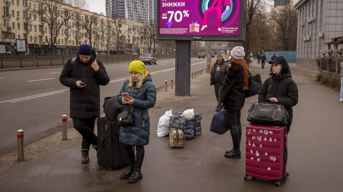 People walk in a subway to get a train as they leave the city of Kyiv, Ukraine, Thursday, Feb. 24, 2022. Russian President Vladimir Putin on Thursday announced a military operation in Ukraine and warned other countries that any attempt to interfere with the Russian action would lead to 