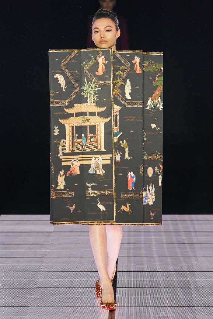 Sebuah pakaian berbentuk partisi lipat dikenakan model Moschino di peragaan busana MFW. Lukisan bergaya Asia Timur terdiri dari orang dan hewan di permukaan partisi seperti mengandung kisah tersendiri. Foto: vogue.com