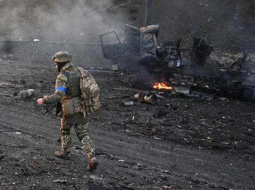 Ukrainian service members look for and collect unexploded shells after a fighting with Russian raiding group in the Ukrainian capital of Kyiv in the morning of February 26, 2022, according to Ukrainian service personnel at the scene. (Photo by Sergei