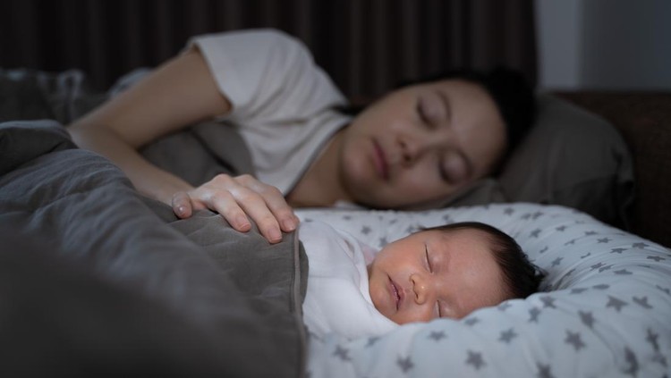ibu dan bayi asian woman mother and baby infant sleeping on bed. infant can sleeping at night with no problem. concept of exhausted mother syndrome. .