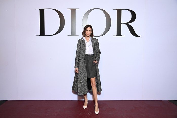 Effortlessly chic, selalu menjadi kata yang tepat mendefinisikan Alexa Chung. Kali ini ia memilih padanan simpel coat, kemeja dan rok dalam warna abu-abu dan putih. Foto: Getty Images For Dior/Pascal Le Segretain