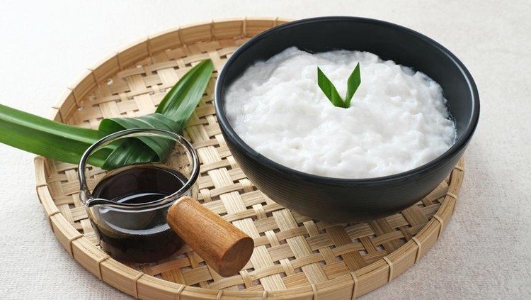Bubur sumsum made from rice flour and coconut milk is traditional Indonesian porridge. Served with brown sugar syrup. Selected focus.