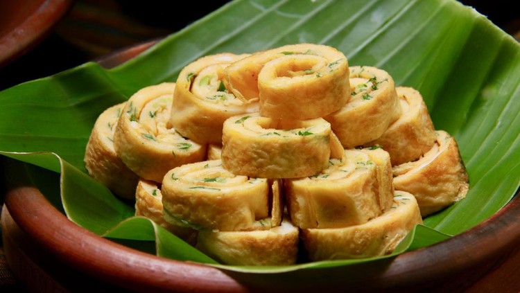 telur dadar Telur Dadar, the egg omelet with scallion slices. the omelet is rolled then sliced into spirals. The spirals are stacked and mounted on an earthenware plate lined with banana leaf.