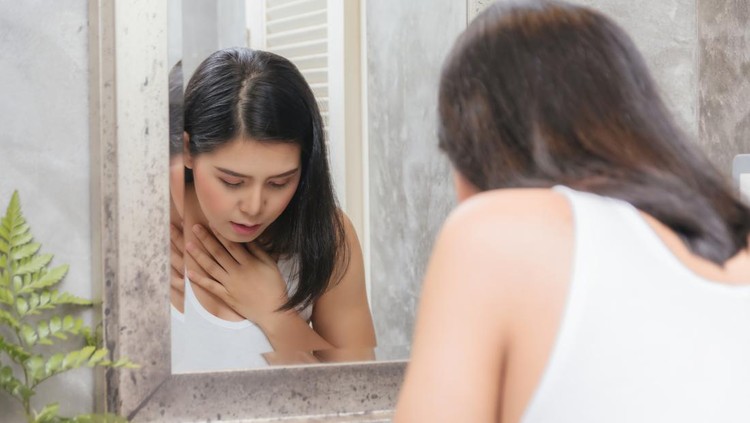 Pregnant woman vomiting into the toilet basin in the early stages of pregnancy.