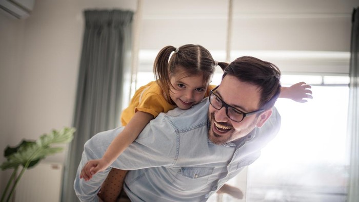 Free as can be. Father and daughter having fun at home.