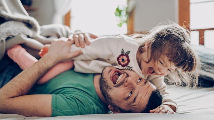 Free as can be. Father and daughter having fun at home.