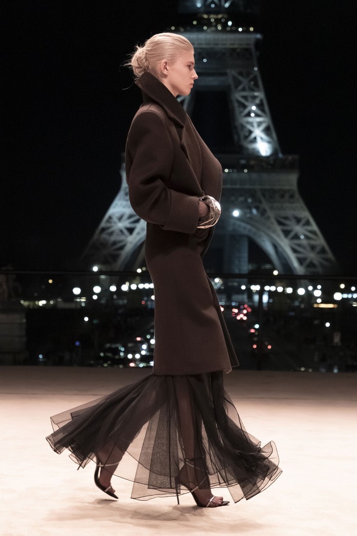 The transparent tulle dress looks elegant when worn with a trench coat.  Anthony Vaccarello as creative director displays a more sophisticated style than usual.  Photo: Courtesy of Saint Laurent