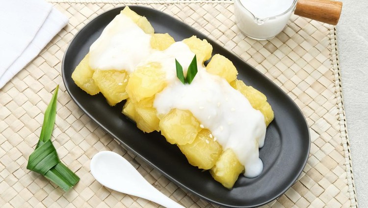 Singkong thailand, sweet cassava, made of boiled cassava, sugar and coconut milk. Served in bowl and pandan leaf, selective focus.