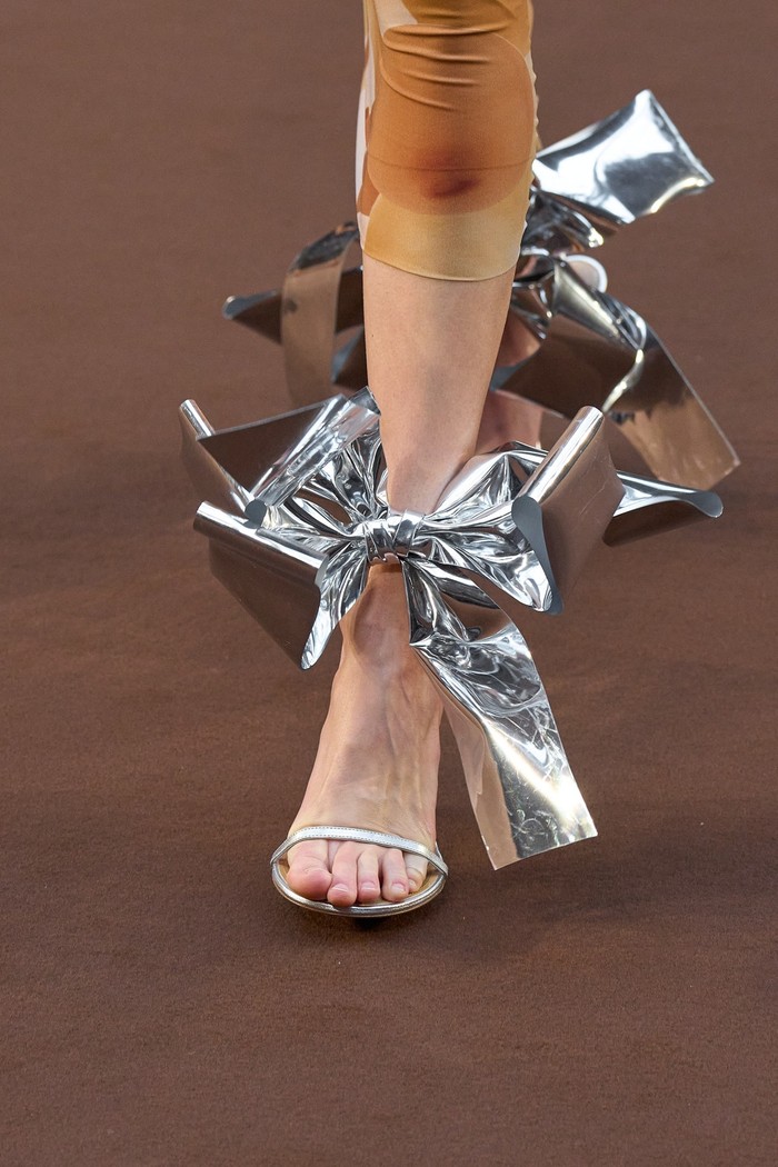 Jika heels detail balon terlalu nyentrik, tampil opsi yang lebih feminin namun dramatis lewat detail pita. Foto: Armando Grillo / Gorunway.com/Vogue