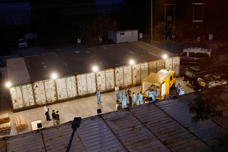 Petugas memindahkan  jenazah ke dalam kontainer berpendingin ksaat kamar jenazah kehabisan ruang di tengah wabah penyakit coronavirus (COVID-19)di Hong Kong, Sabtu (5/3/2022). (REUTERS/Tyrone Siu)