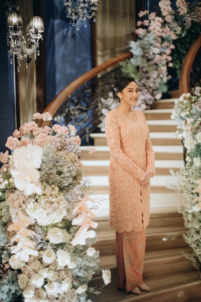 Putri tampak elegan dalam balutan kebaya desainer Sapto Djojokartiko serta pulasan makeup dari Bubah Alfian. Dekorasi venue dari Stupa Caspea dengan nuansa bunga-bunga berwarna lembut dan nuansa peach, sangat serasi berpadu dengan kebaya dan batik Putri serta Guinandra. /Foto: Dok. Morden.co