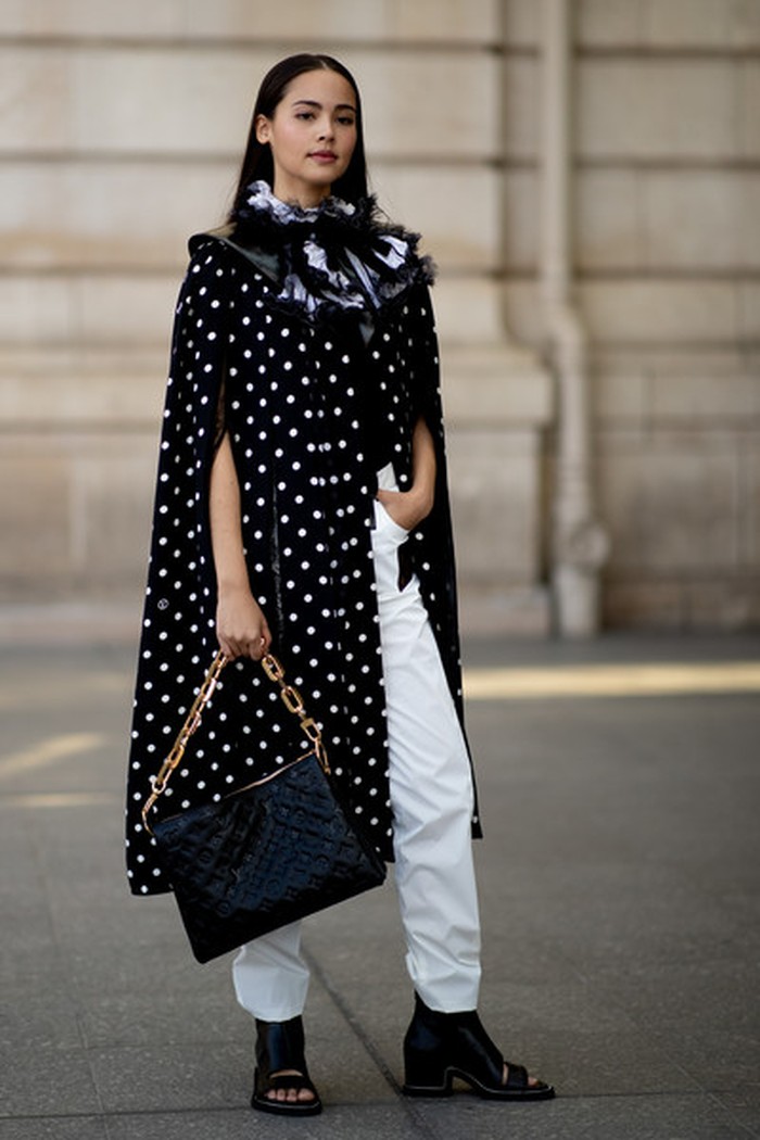 Aktris asal Thailand, Urassaya Sperbund terlihat hadir dalam peragaan busana Louis Vuitton dalam balutan busana black & white. Cape polkadot dengan aksen kerah ruffled lace dan pita membuat penampilannya eye-catching. Foto: livingly.com/ImaxTree