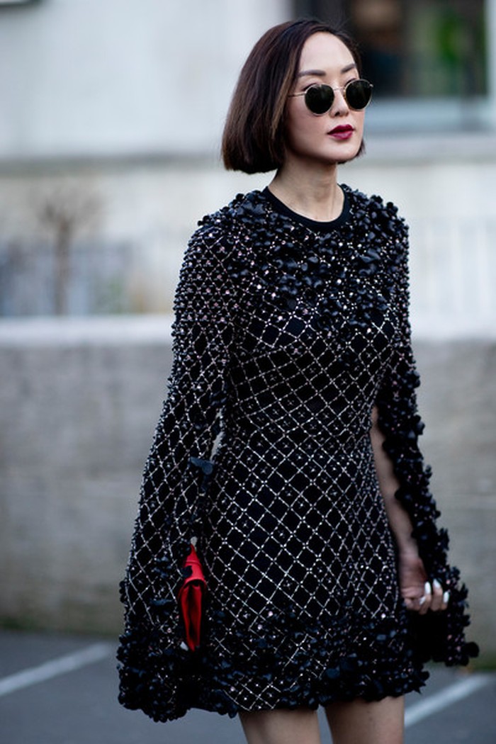 Glamor dan chic, tapi tetap minimalis. Fashion blogger Chriselle Lim mengkoordinasikan dress hitam penuh embellishment dengan sunglasses bundar dan clutch merah yang mencolok. Foto: livingly.com/ImaxTree