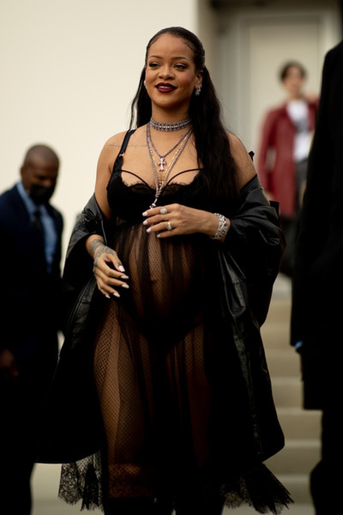 Rihanna tampil seksi saat menghadiri fashion show Dior. Ia memakai gaun transparan hitam yang melapisi lingerie berwarna senada, disempurnakan dengan layering kalung dan boots. Foto: livingly.com/ImaxTree
