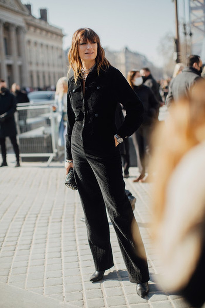 Style icon berkebangsaan Prancis, Caroline de Maigret menampilkan gaya all-black look terdiri dari jumpsuit, leather boots, clutch, kalung bertumpuk, dan jam tangan yang maskulin. Foto: livingly.com/ImaxTree
