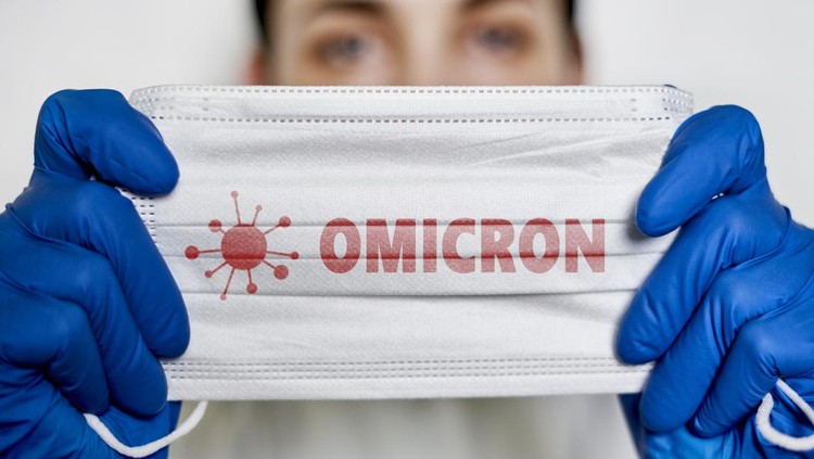 Female doctor holds a face mask with - Omicron variant text on it. Covid-19 new variant - Omicron. Omicron variant of coronavirus. SARS-CoV-2 variant of concern