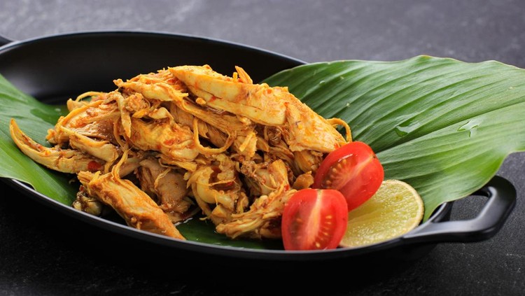 Ayam Sisit or Ayam Suwir is a Balinese Cuisine Made from Spicy Chunks of Chicken Meat, Served on Black Plate. Copy Space for Text