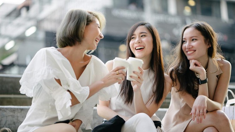Young beautiful women shopping together&comma; outdoors&comma; smiling&comma; using smartphone