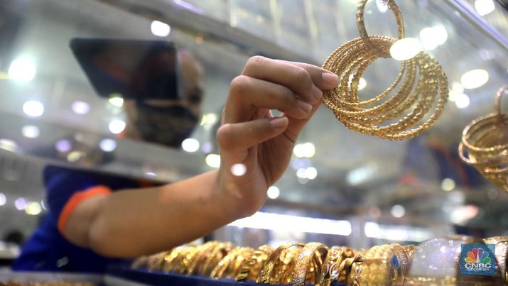 Pekerja menata perhiasan emas di toko emas Kawasan Pasar Ciputat, Tangerang Selatan, Jumat (11/3/2022). Harga emas dunia bergerak melemah pada perdagangan hari ini. (CNBC Indonesia/ Muhammad Sabki)