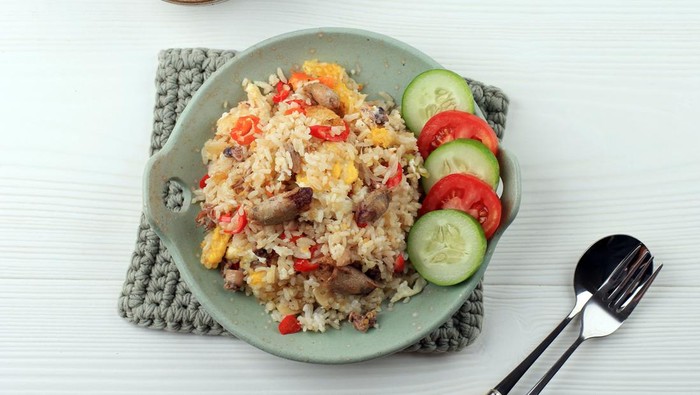 Nasi Goreng Cumi Asin (Fried Rice with Salted Squid), Cooked with Chilli, Spicy and Delicious. Typical Indonesian Homemade Food. Served on Green Plate, Isolated on White Background. Top View
