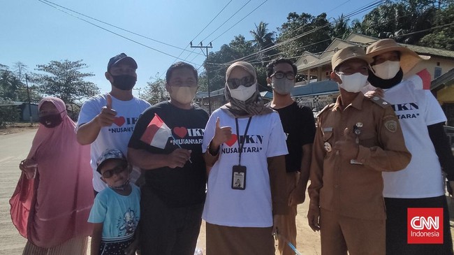 Sejumlah warga Desa Bukit Raya, Kecamatan Sepaku, di pinggir jalan menyambut Jokowi yang hendak ke titik nol sambil memakai kaos bertuliskan 'I Love IKN'.
