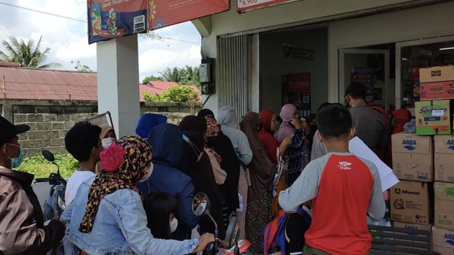 Warga di Penajam, Kabupaten Penajam Paser Utara, Kaltim mengantre membeli minyak goreng yang dijatah di sebuah retail dengan syarat menunjukkan salinan KK.