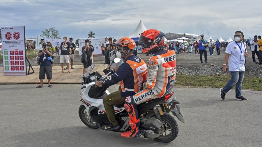Pembalap Repsol Honda Team Marc Marquez membonceng marshal usai terjatuh saat kualifikasi MotoGP di Pertamina Mandalika International Street Circuit, Praya, Lombok Tengah, NTB, Sabtu (19/3/2022). Pembalap Monster Energy Yamaha Fabio Quartararo merebut pole position dan berhak start terdepan pada balapan MotoGP seri kedua 2022 pada Minggu (20/3) setelah mencatatkan waktu tercepat 1 menit 31,067 detik.ANTARA FOTO/Ahmad Subaidi/rwa.