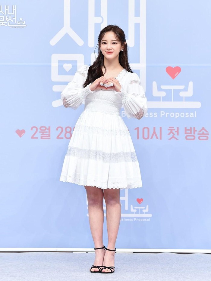 Mau hangout bareng pacar? Coba contek gaya Se Jeong saat press conference Business Proposal. Ia memakai gaun poplin selutut dengan detail renda. Manis banget, kan?/ Foto: instagram.com/sbsdrama.official.