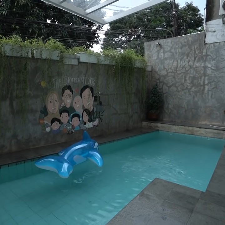 <p>Pada bagian halaman, terdapat kolam renang anak bernuansa modern. Kolam ini sengaja dirancang tidak dalam agar tak membahayakan anak-anak. Zaskia bercerita, ia menjadi khawatir ketika tetangga mereka kehilangan anak berusia 3 tahun yang tenggelam di kolam renang ketika orang tuanya sedang tak berada di rumah. (Foto: YouTube The Sungkars)</p>