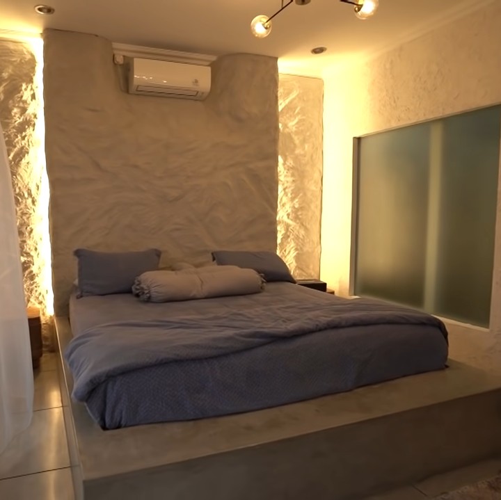 <p>Menariknya, kamar utama di rumah mereka terlihat sangat modern dengan desain yang menyerupai vila. Mereka sengaja memilih tembok bertekstur dan memakai <em>stripe light</em> untuk menciptakan suasana <em>cozy.</em> (Foto: YouTube The Sungkars)</p>