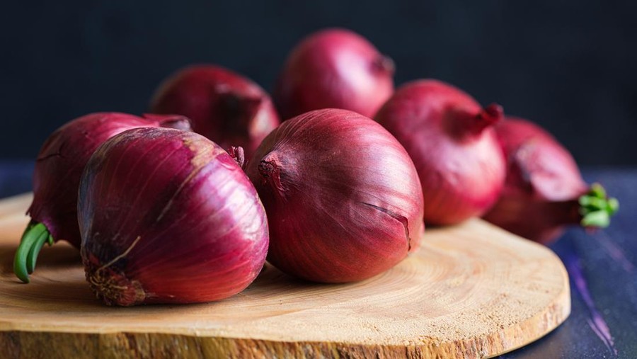Red onions on wood board