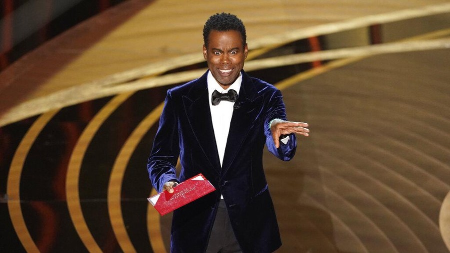 Chris Rock presents the award for best documentary feature at the Oscars on Sunday, March 27, 2022, at the Dolby Theatre in Los Angeles. (AP Photo/Chris Pizzello)