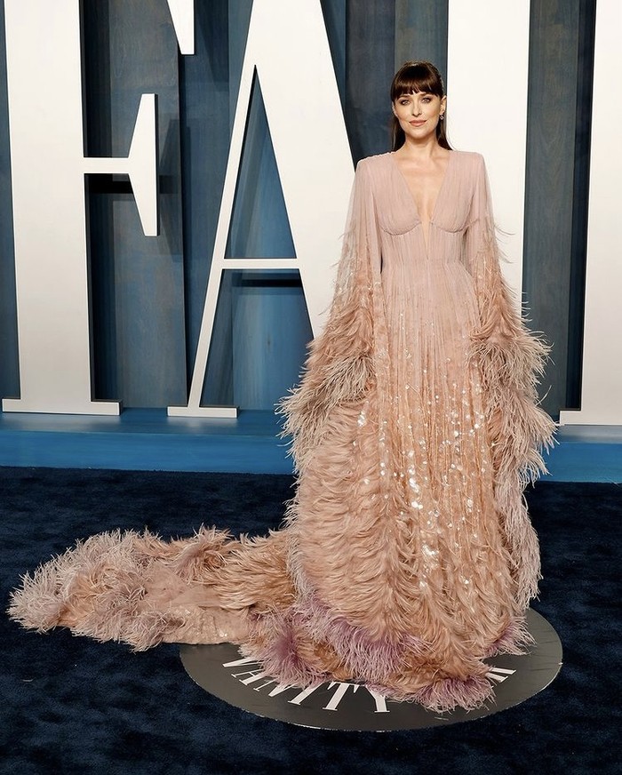 Dakota Johnsson tidak pernah absen memesona publik dengan gaya glamornya. Masih memercayakan outfit pada Gucci, ia tampil dalam gaun penuh bordir––detail bulu dan sequin sepanjang lengan, rok, dan train. Foto: instagram.com/gucci