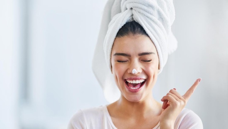 ilustrasi skincare Shot of a beautiful young woman applying moisturizer to her skin in the bathroom at home