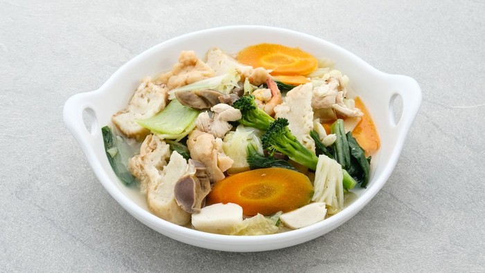 Capcay seafood, Capcay kuah, stir fried vegetables with shrimp and chicken. Served in white plate on grey background.