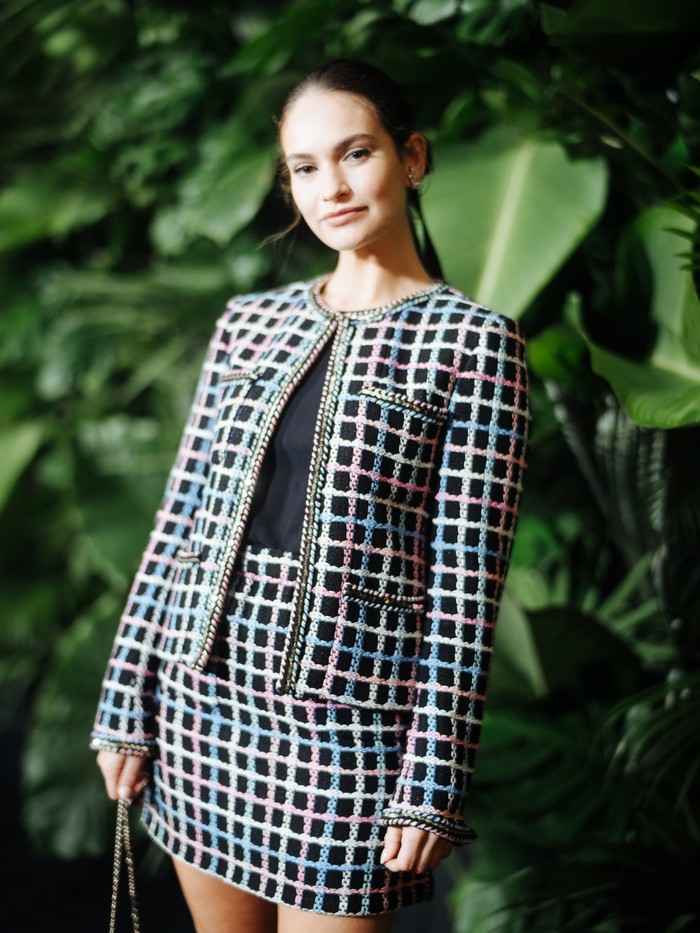 Aktris Lily James memakai setelan rok garis multi warna kreasi Chanel. Potongan rok pendek kian memberi nuansa modern dan fun pada busana klasik ini. Foto: Courtesy of Chanel