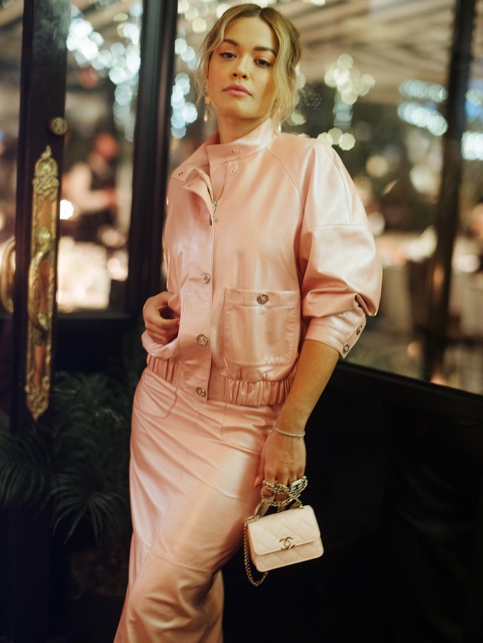 Isn't she lovely? Rita Ora terlihat feminin dan elegan dalam balutan jaket dan rok kulit warna pink. Foto: Courtesy of Chanel