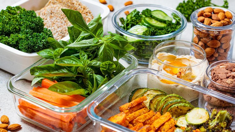 Preparing healthy meals for the week. Vegan food and snacks in containers, gray background. Flat lay cooking food.