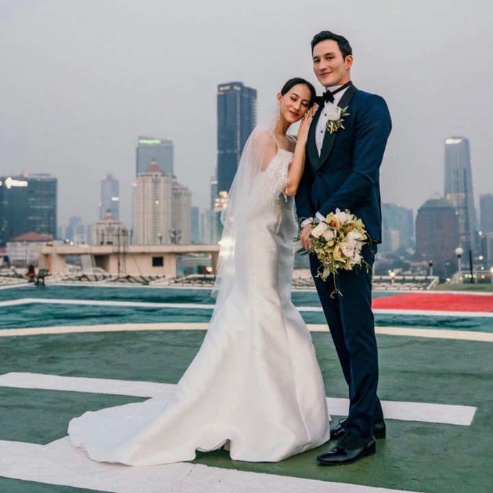 <p>Mike terlihat gagah dengan menggunakan setelan jas berwarna biru dongker yang dipadukan dengan warna hitam. Sedangkan Janisaa terlihat cantik dengan gaun pernikah berwarna putih. (Foto: Instagram: @mike_lewis)</p>