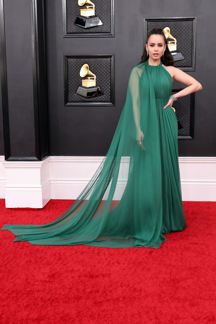 Gaun detail cape kreasi Valentino juga dipilih Sofia Carson dalam warna hijau yang sarat statement.Foto: Valentino/GettyImages