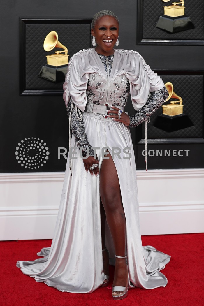 Hanya aktris Cynthia Erivo yang bisa menampikan perpaduan gaun detail kerutan, bordir, dan sabuk bersama atasan lengan panjang mengkilap jadi terliaht stylish dan edgy. Busana tersebut merupakan rancangan Louis Vuitton. Foto: REUTERS/MARIA ALEJANDRA CARDONA